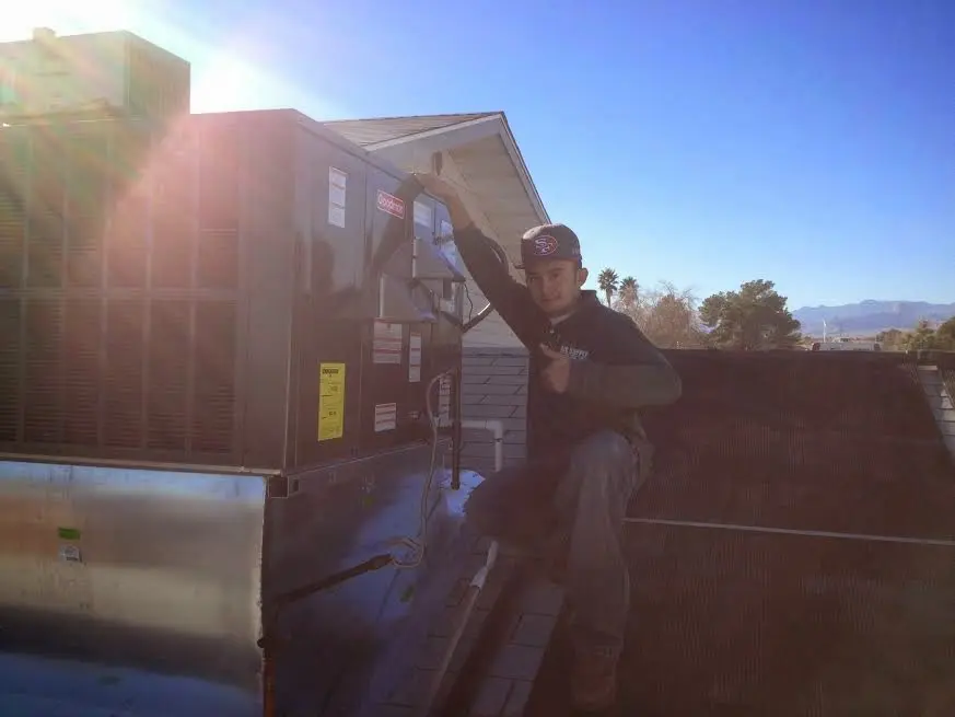 HVAC technician performing AC Tune-Up on a rooftop unit in Laurens
